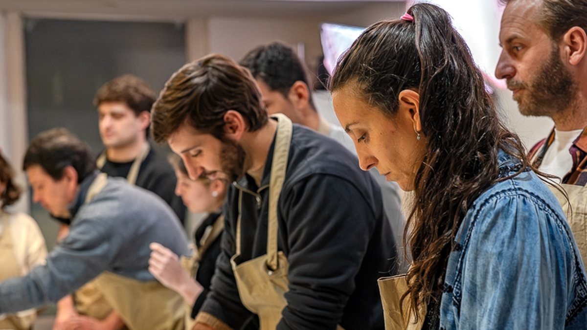 El grupo trabajando alrededor de la mesa en la Cena y Taller de Tapeo